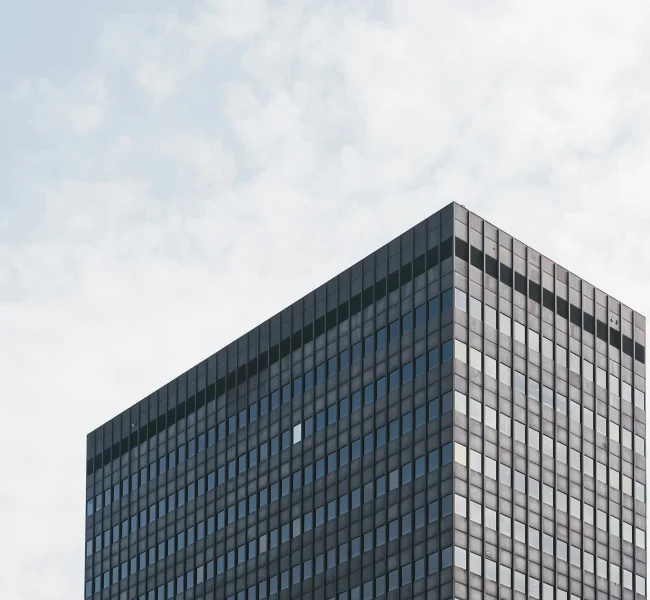 Hohes Bürogebäude mit dunkler Glasfassade, Perspektive von unten